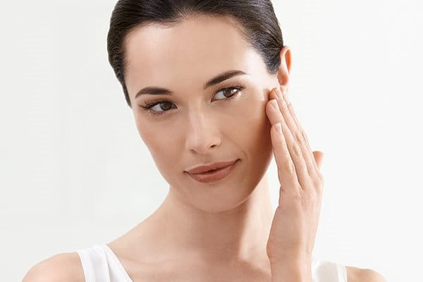 Жена нанася концентрата в зоната около очите